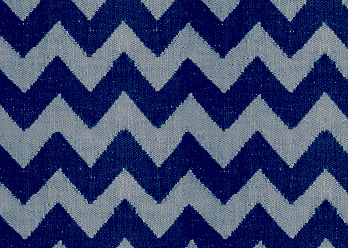 Close view of a blue and white chevron cotton rug